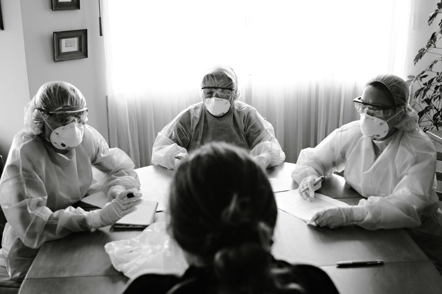 Business team meeting around conference table discussing crisis management strategy
