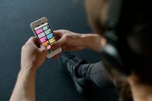 Person wearing headphones while using music streaming app on smartphone