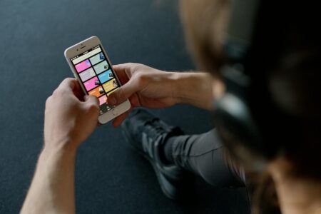 Person wearing headphones while using music streaming app on smartphone