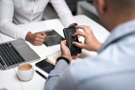 Person analyzing social media analytics on smartphone screen showing graphs and performance metrics