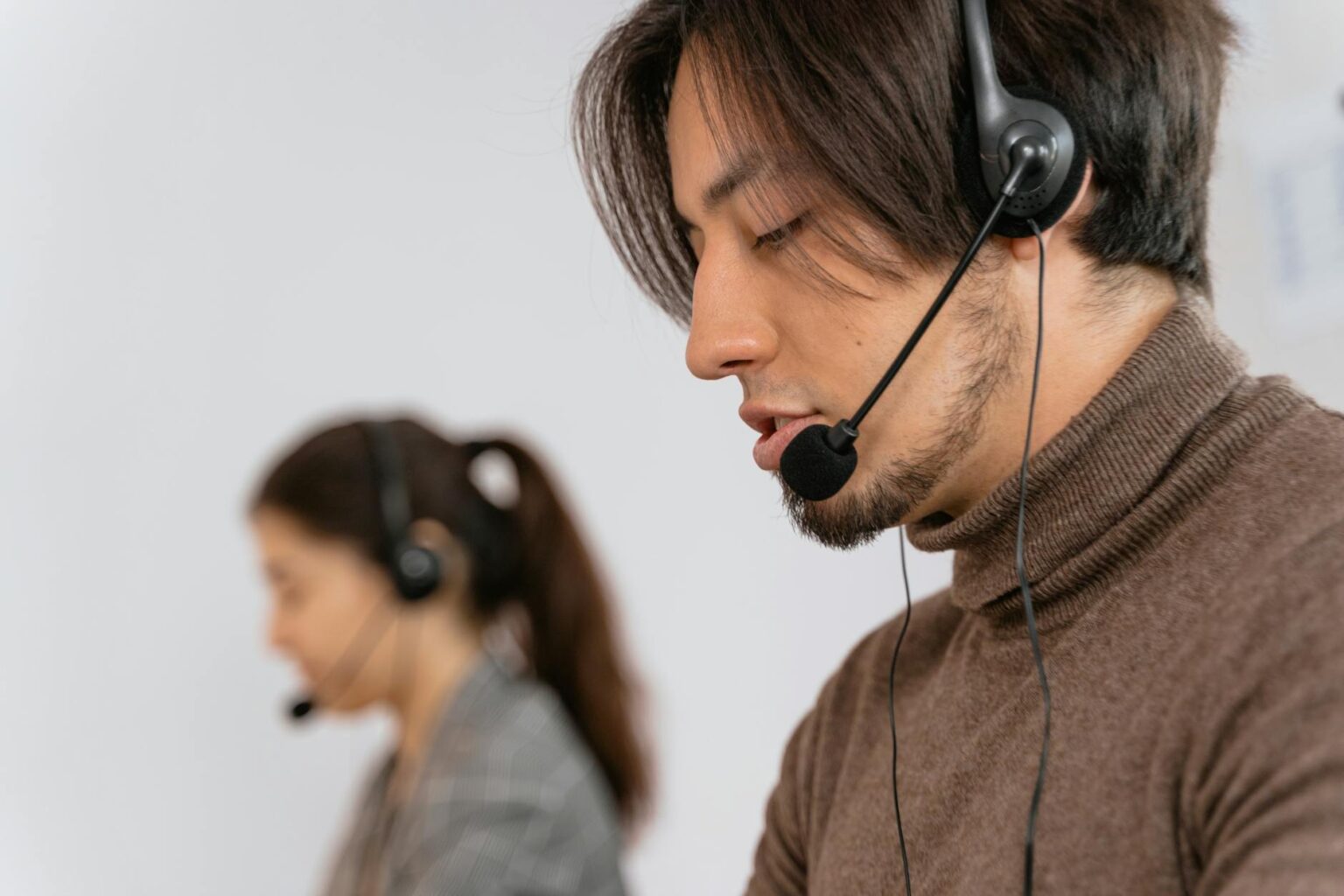 Customer service representative wearing headset while working at computer desk