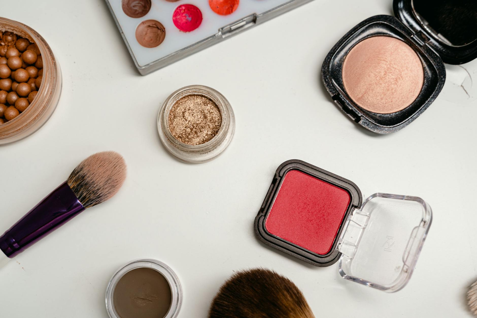 Various beauty products arranged on clean white surface showing modern cosmetics industry
