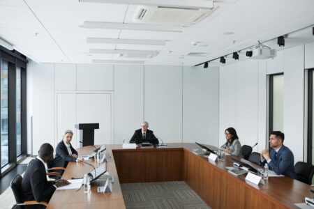 Professional business meeting with people discussing strategy around a conference table