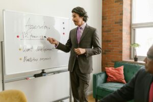 Business team planning product strategy on whiteboard with charts and diagrams