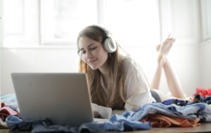 Person wearing headphones while working on laptop, representing music streaming and digital marketing