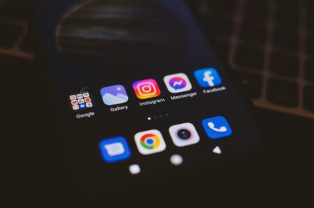 Hand holding smartphone displaying Instagram profile with Story Highlights visible below bio section
