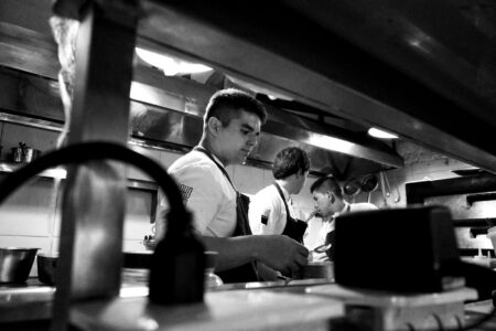 Clean commercial kitchen with chefs preparing fresh ingredients