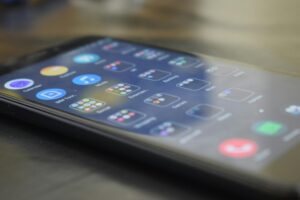 Person checking weather forecast on smartphone screen showing sunny conditions and temperature
