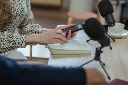 Person using smartphone voice search feature with microphone icon displayed on screen