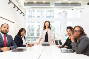 Professional business meeting with team members discussing strategy around conference table