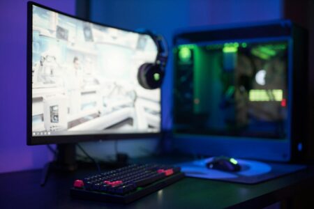 Professional gaming setup with multiple monitors and RGB lighting in dark room