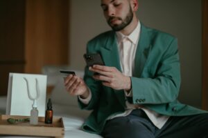 "Person using smartphone to browse and shop online with shopping cart icon visible on screen"