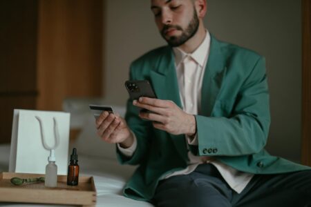 "Person using smartphone to browse and shop online with shopping cart icon visible on screen"