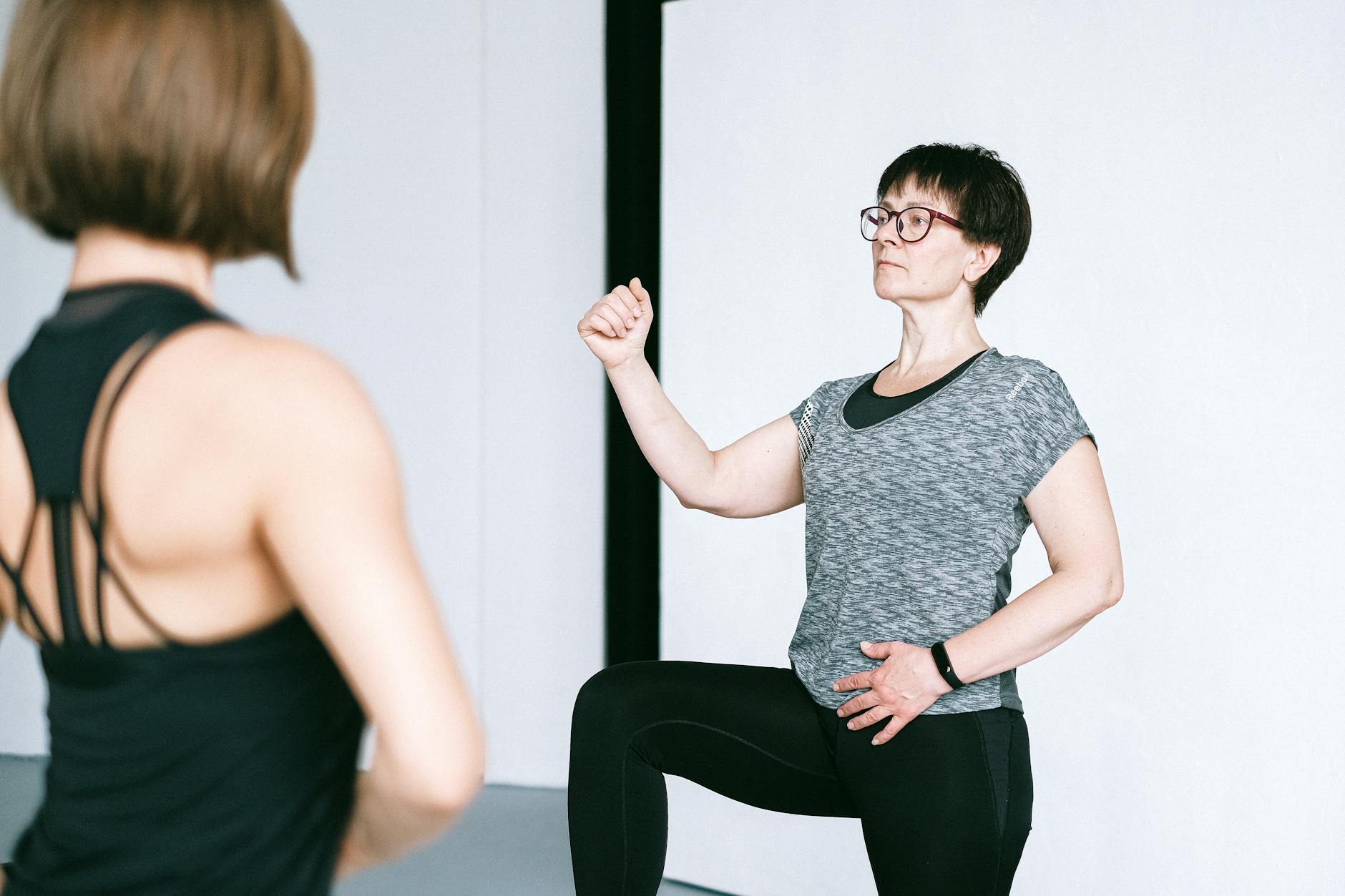Fitness instructor demonstrating exercise technique to engaged group of students