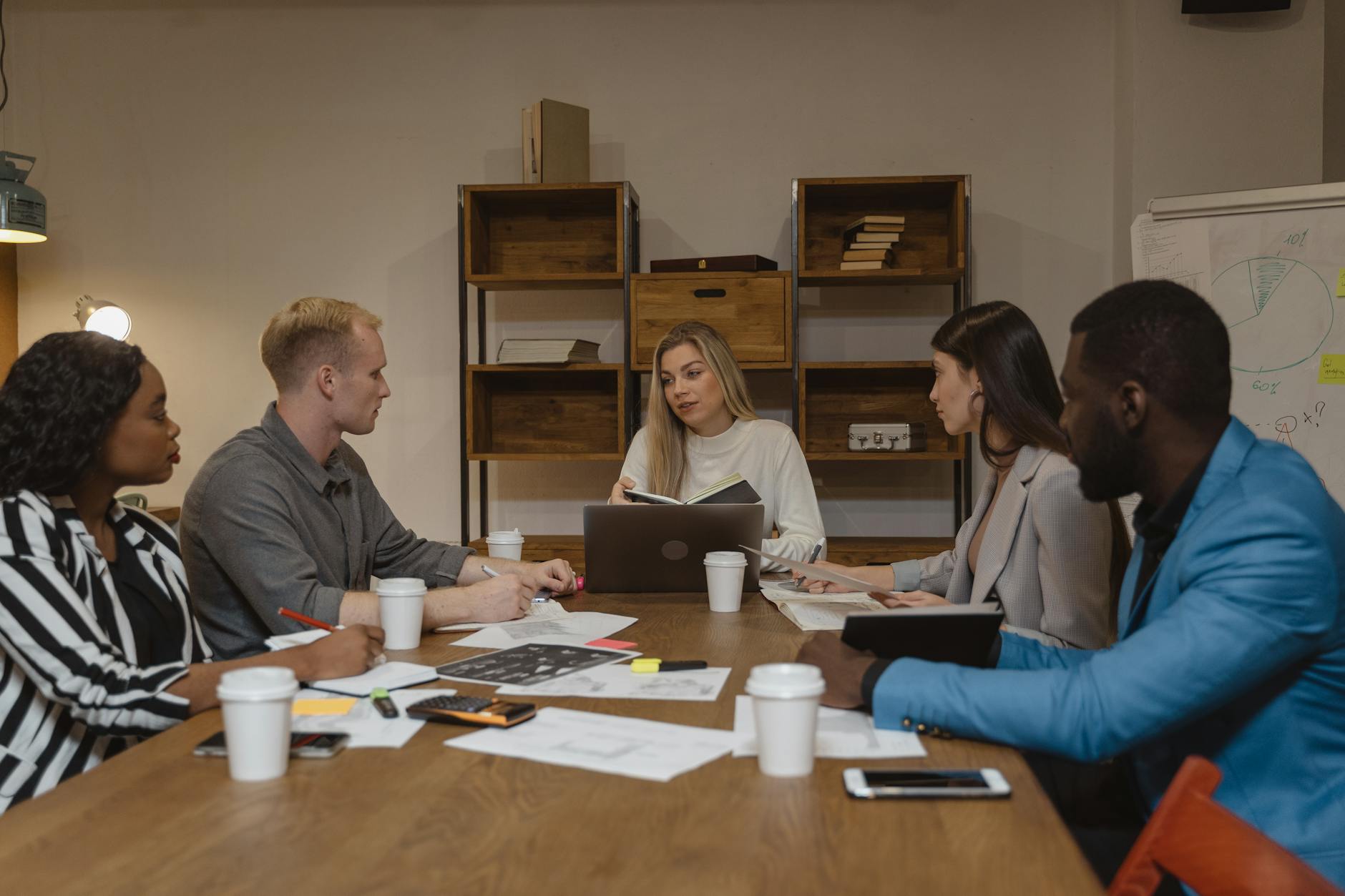 Business team collaborating around table reviewing feedback and research insights