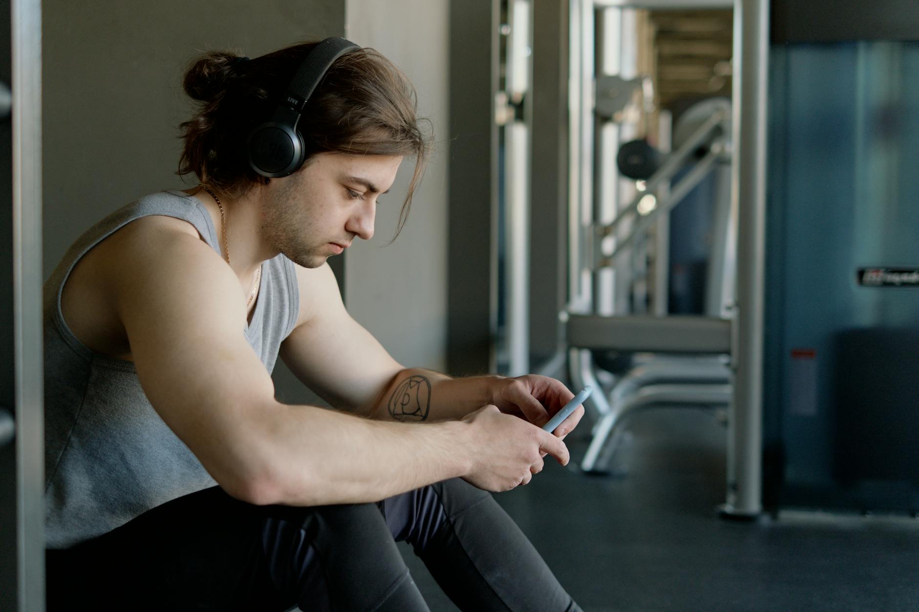 Person using smartphone fitness app showing workout progress and achievement badges
