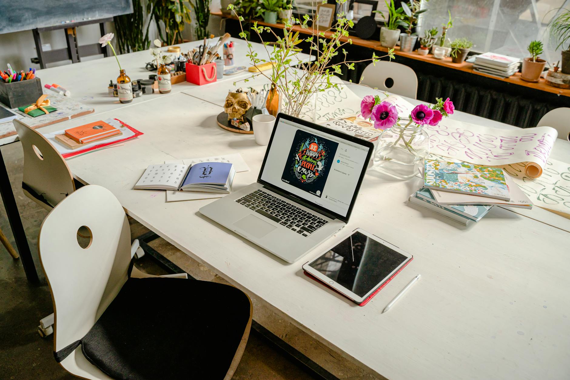 Organized creative workspace with laptop, notebooks, and planning materials for content creation