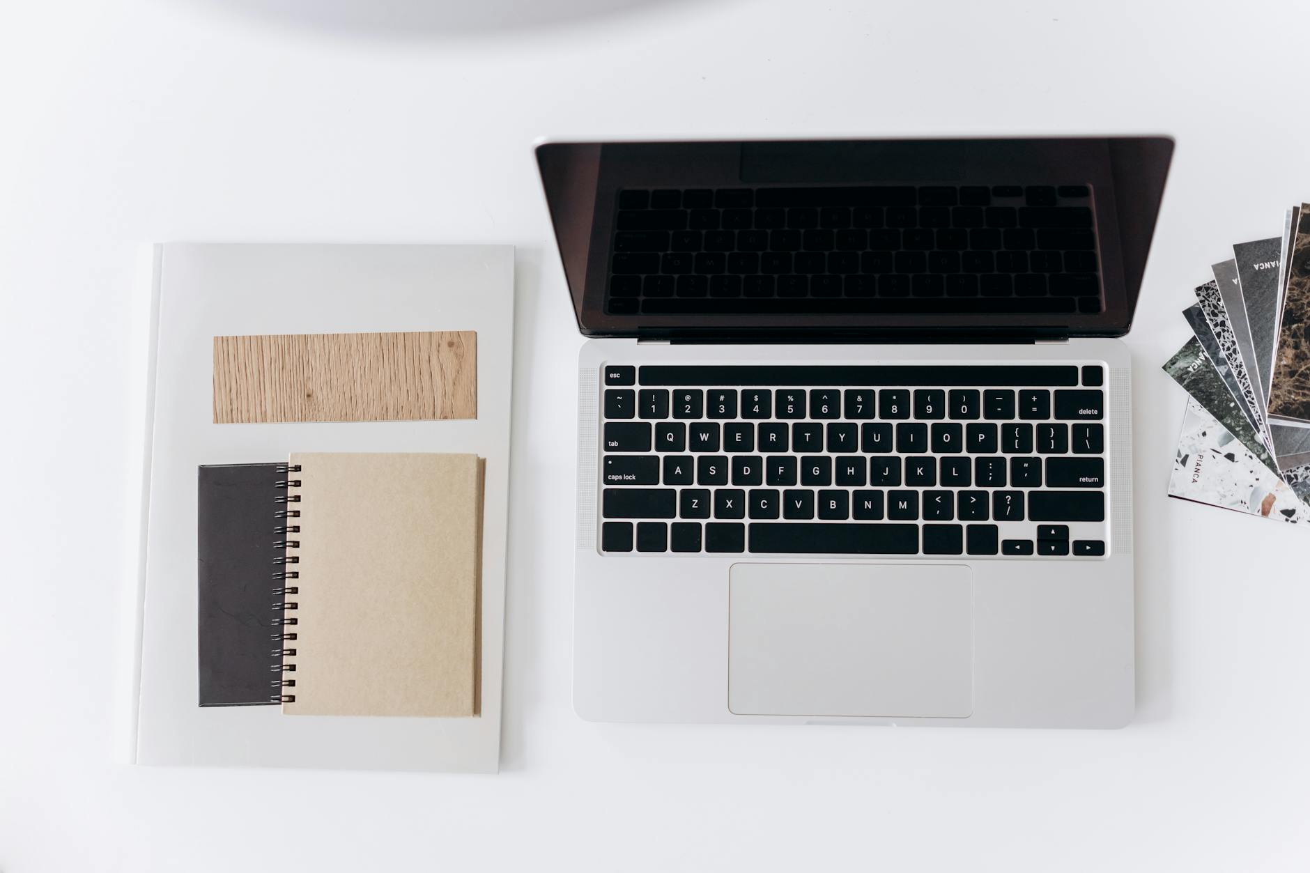 Clean laptop workspace with coffee cup and notebook for productivity