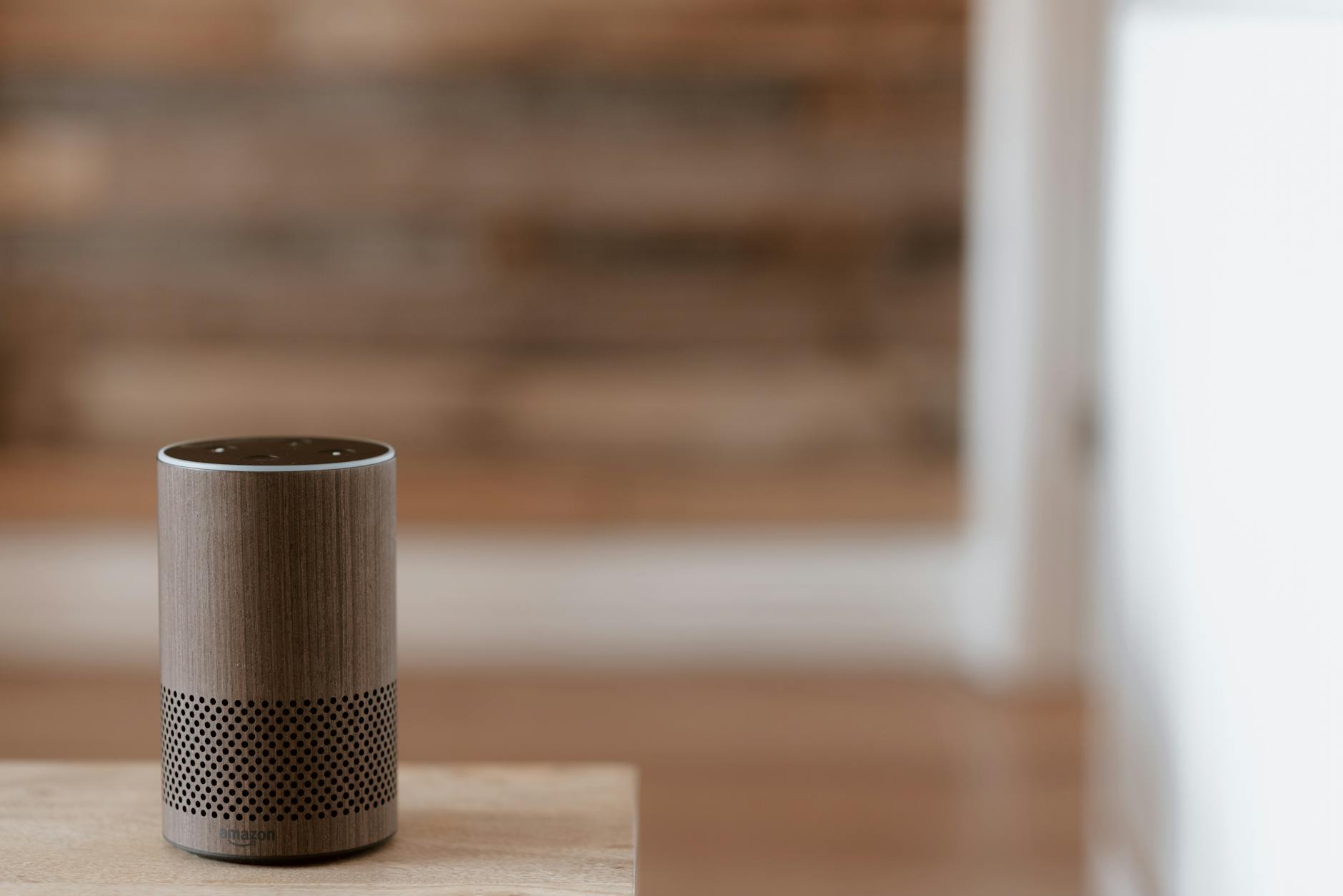 Modern smart speaker device on home table with ambient lighting in background