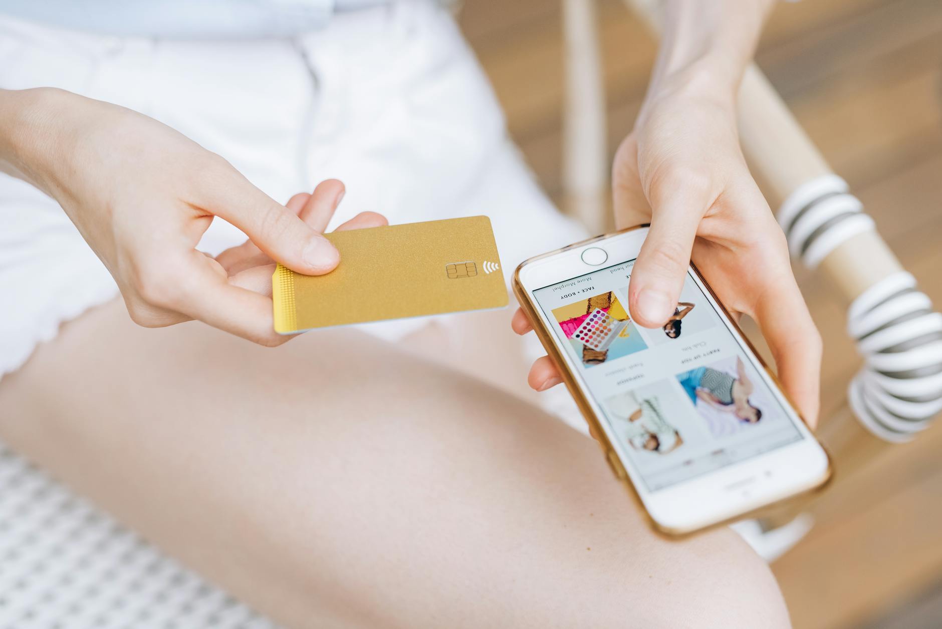 Person using smartphone for online shopping with fashion items on screen