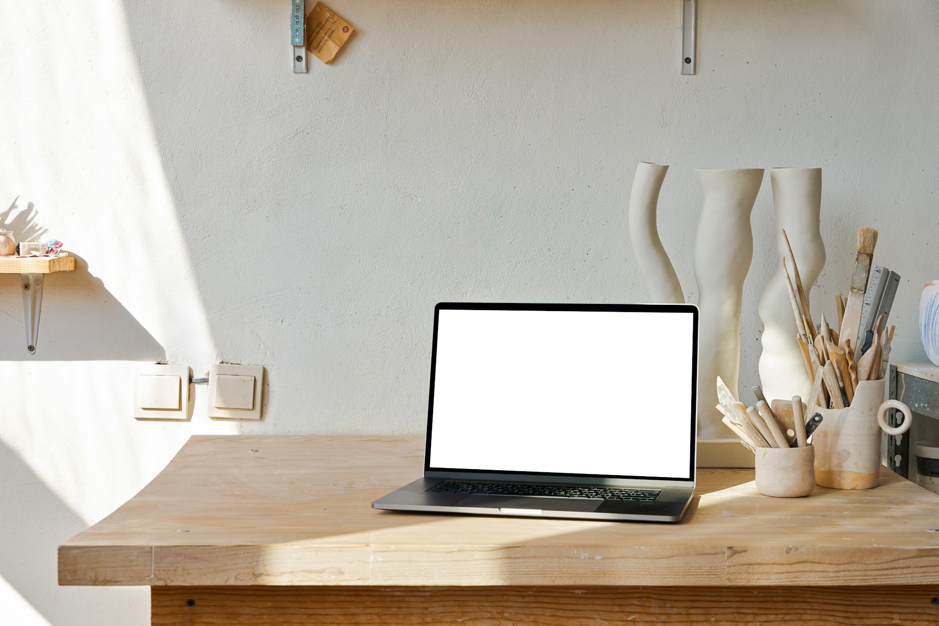 Modern marketing workspace with laptops, notebooks, and planning materials for campaign development