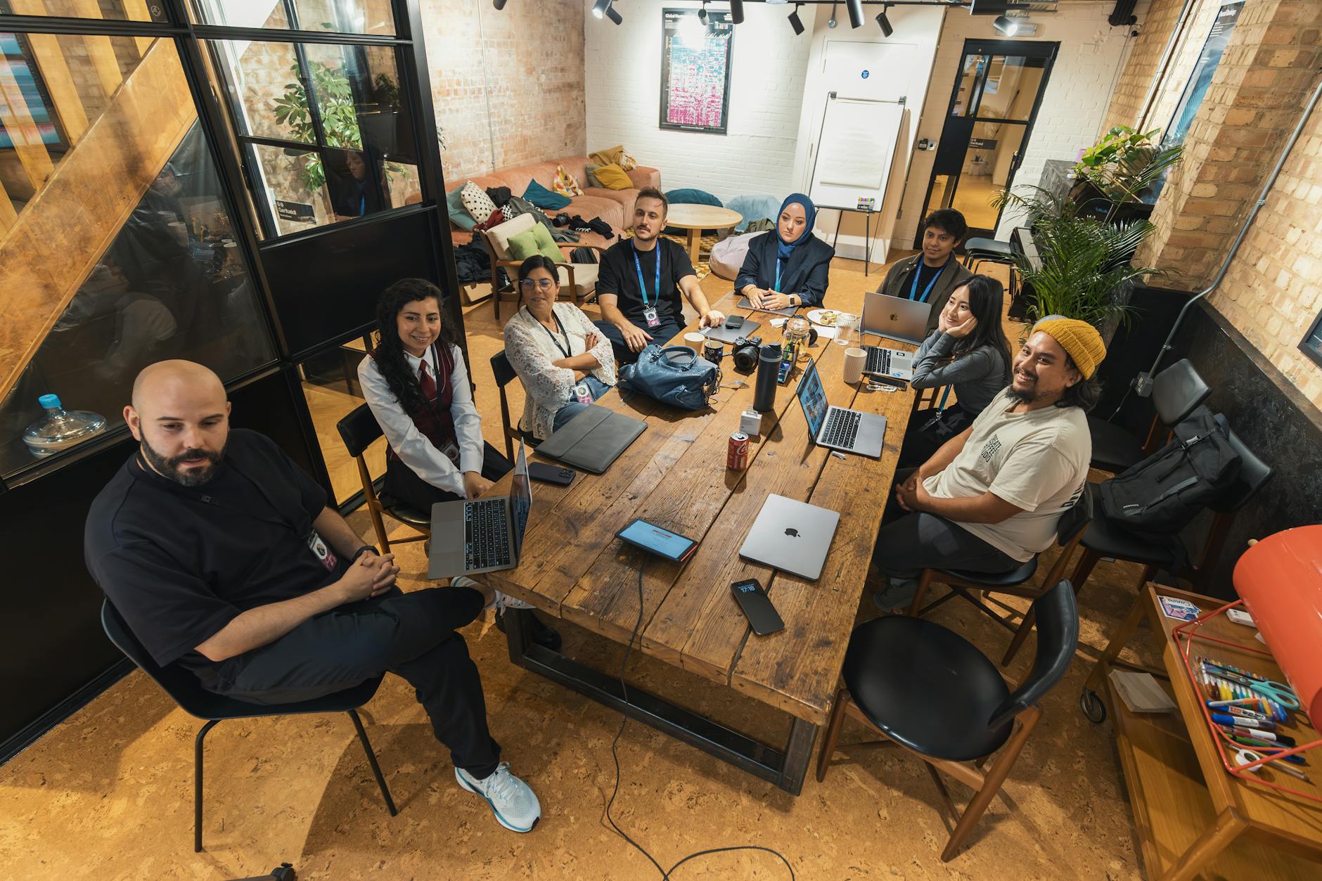 Marketing team reviewing user-generated content strategy on laptops and tablets in office setting