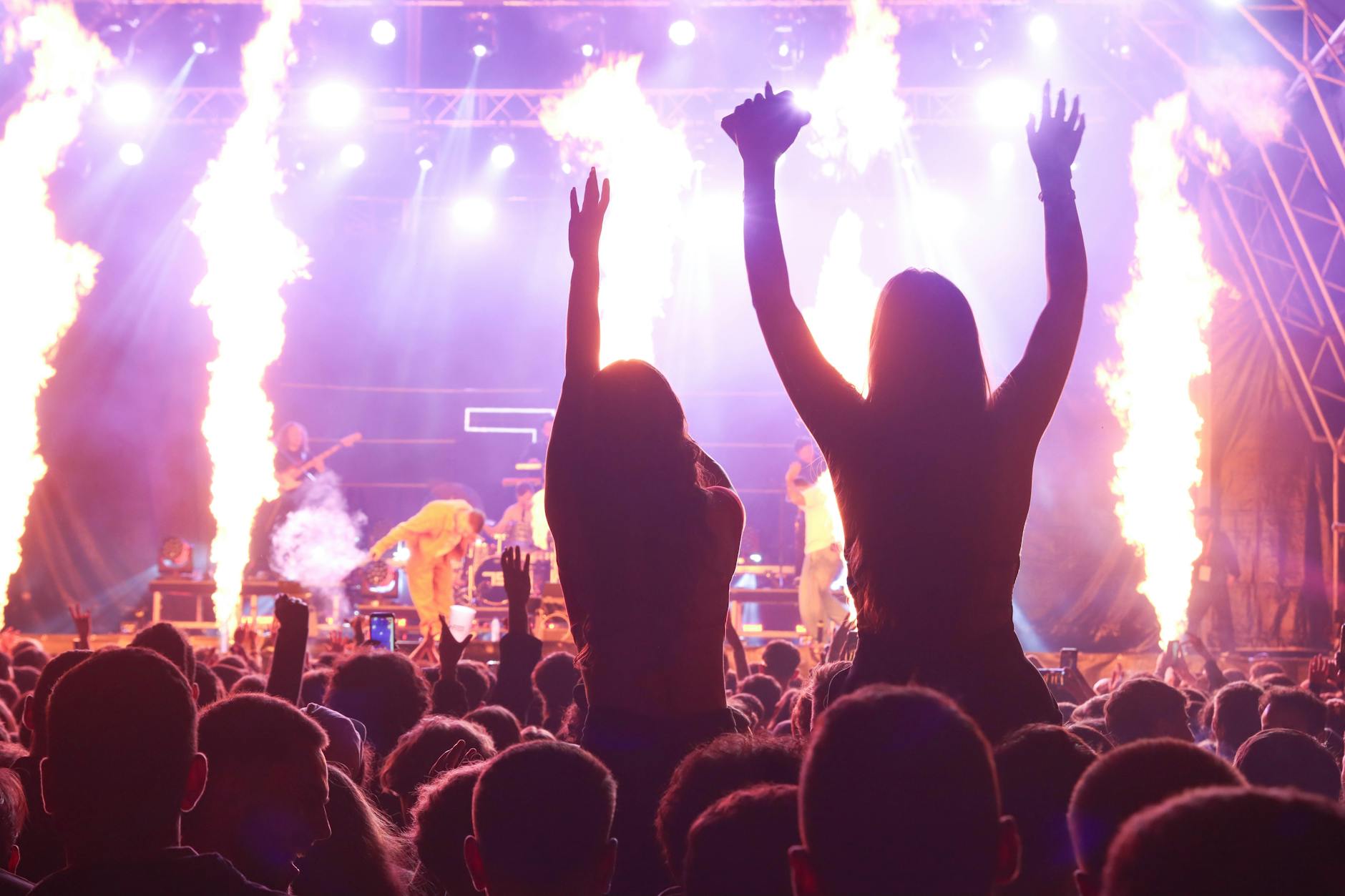 Concert audience holding up phones recording live music performance