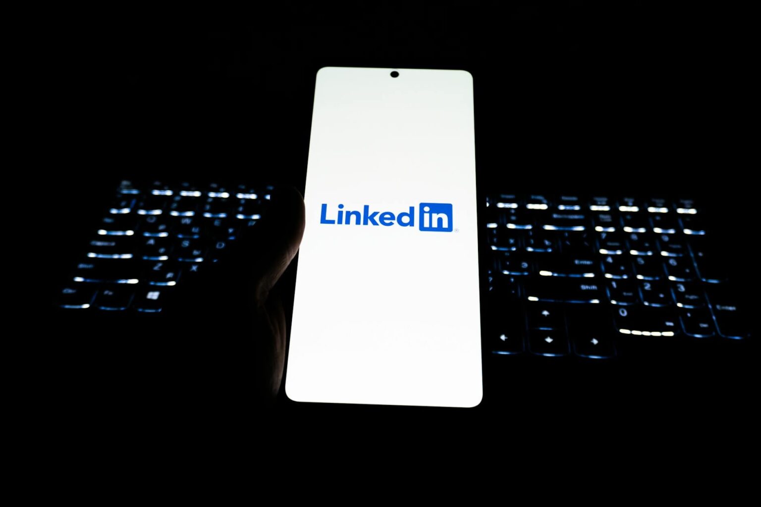 LinkedIn’s Poll Algorithm Is Quietly Boosting Organic B2B Reach Person scrolling LinkedIn feed on a smartphone showing poll content