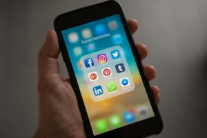 Person scrolling LinkedIn feed on a mobile device showing sponsored content