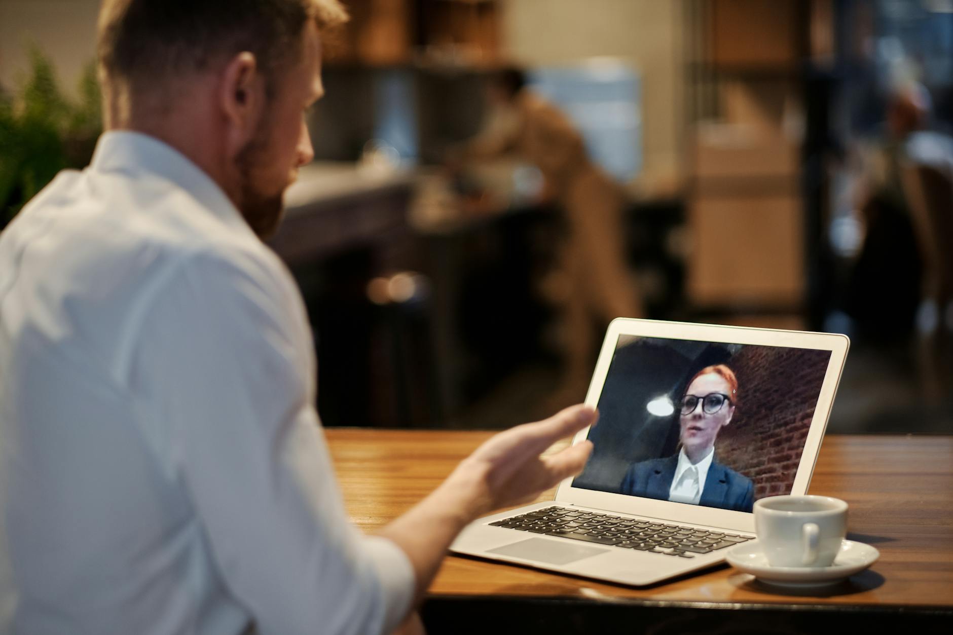 Person attending a virtual professional meeting on a laptop at a modern desk