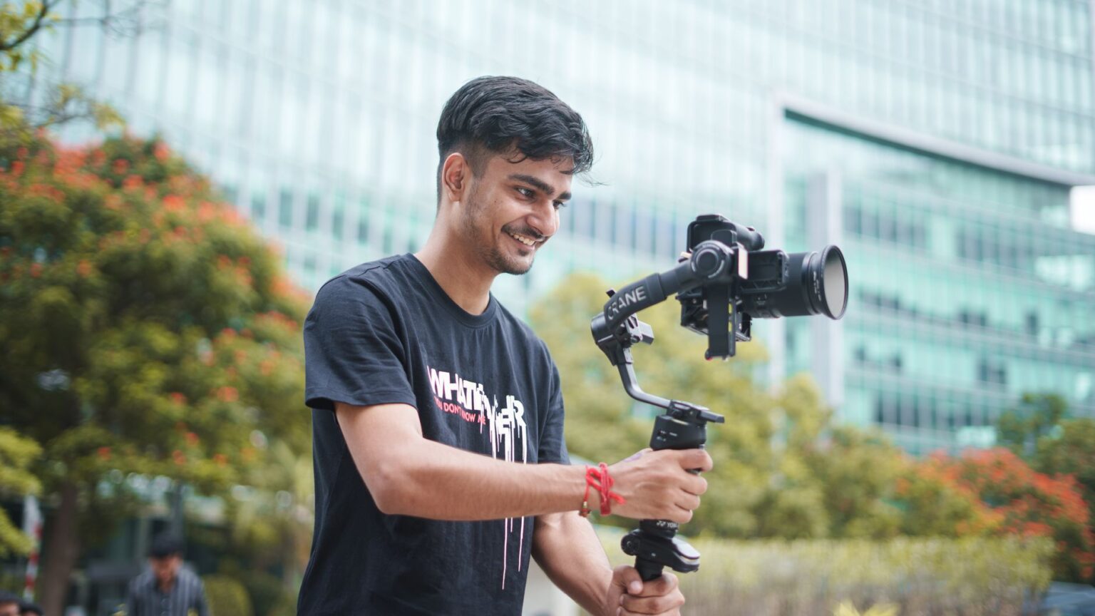 A content creator filming a video tutorial at a desk with camera and lighting equipment