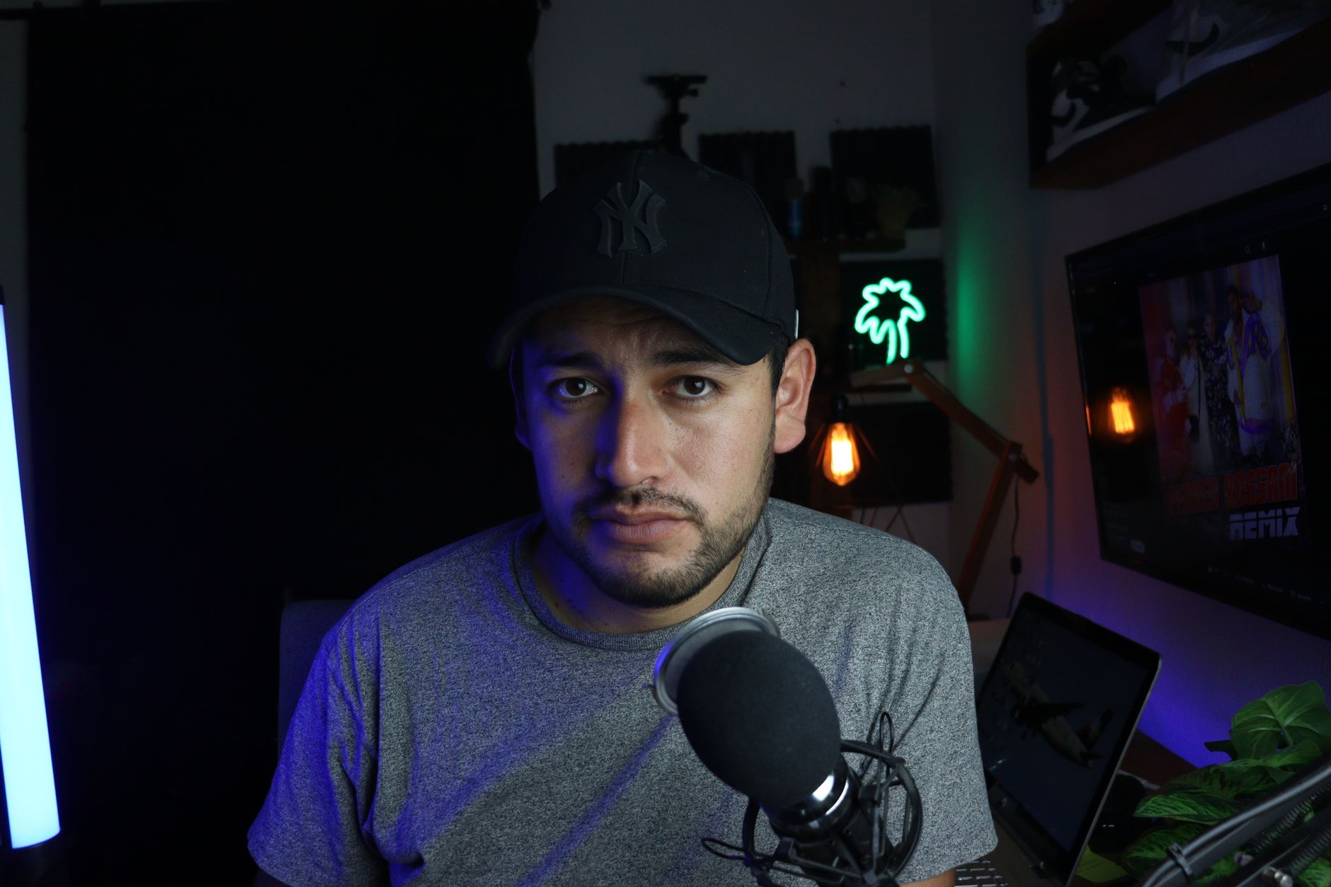 A person recording video content at a desk setup with camera and monitor