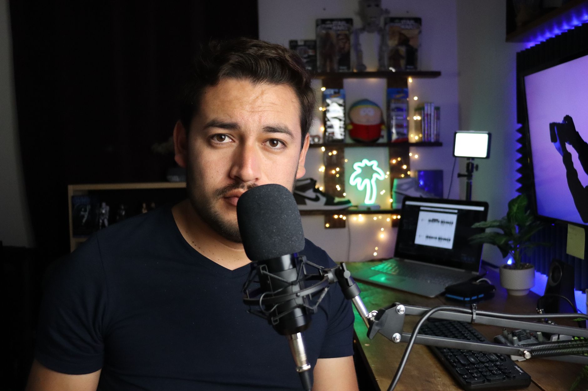 An independent content creator working at a home office desk with a monitor