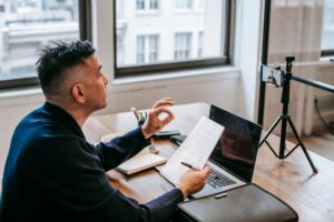 Professional team member on a video call taking notes during a client meeting