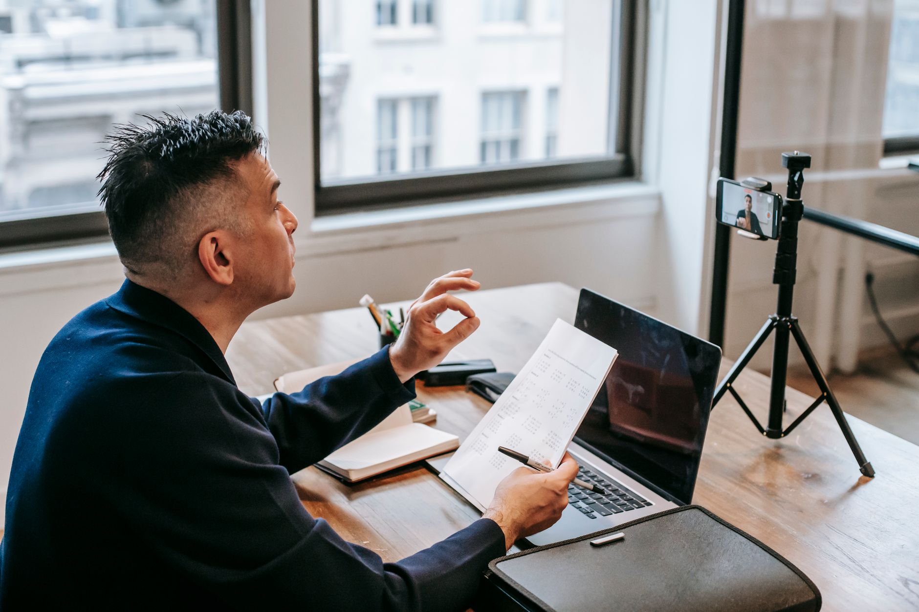 Professional team member on a video call taking notes during a client meeting