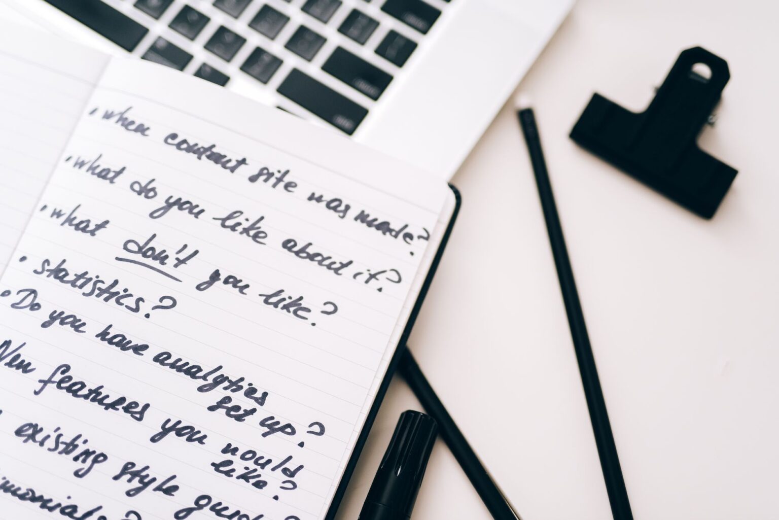 A creator working at a desk with a laptop and project notes spread out