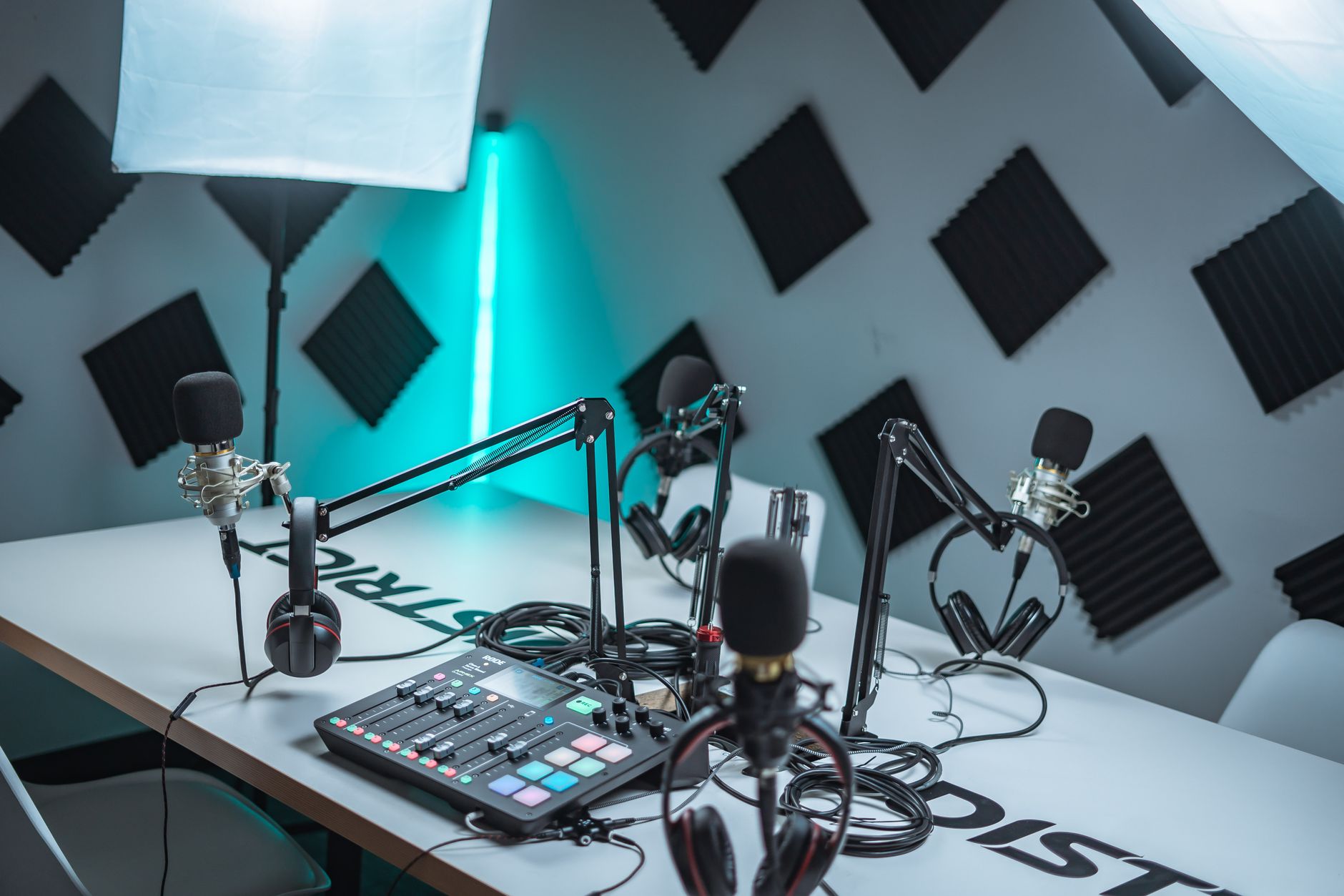 A podcaster recording in a professional studio setup with microphone and headphones