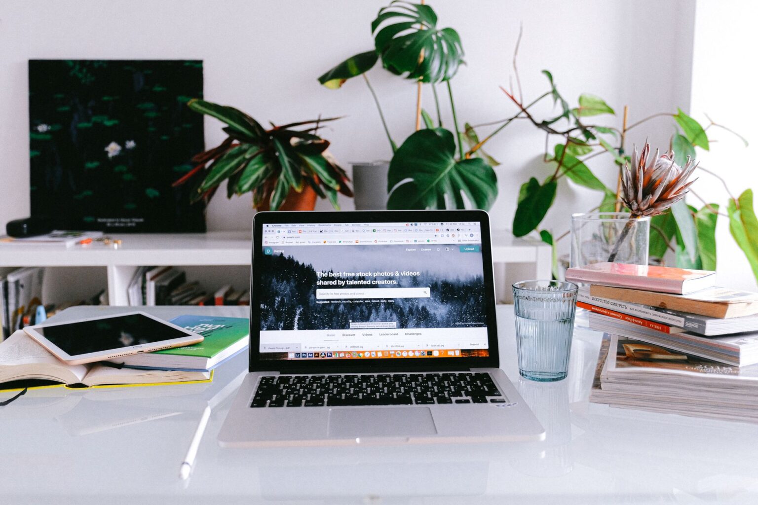 Freelancer working at a home desk with multiple screens showing social media dashboards