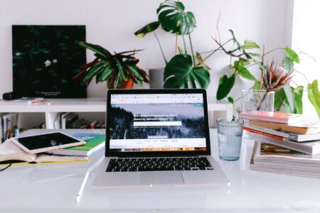 Freelancer working on a laptop in a home office, managing multiple browser tabs