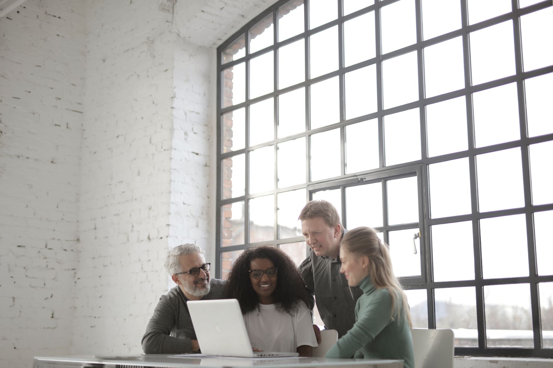 Small team of colleagues reviewing messages and tasks together at a shared desk
