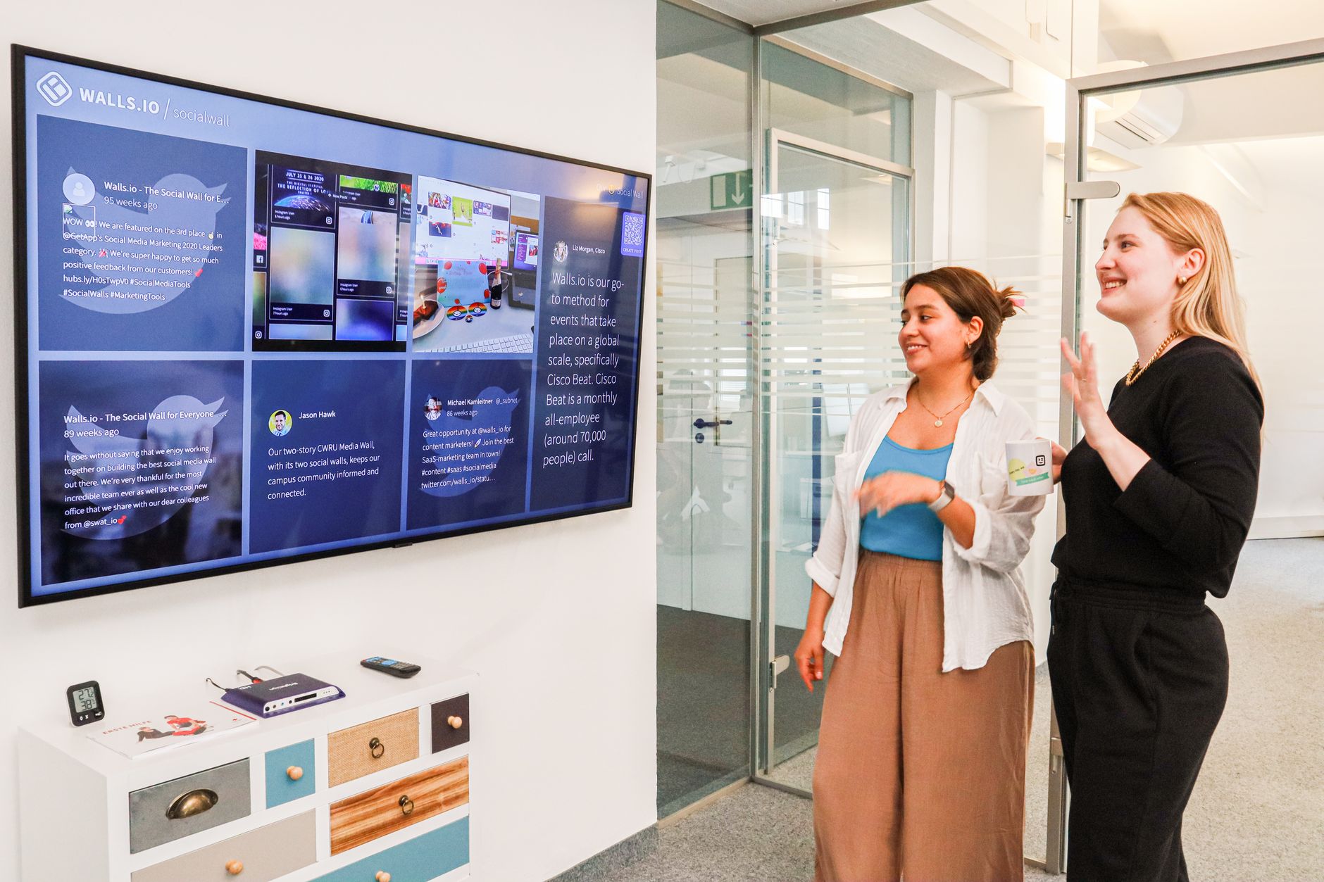 Social media team reviewing content on laptops and tablets in a modern office