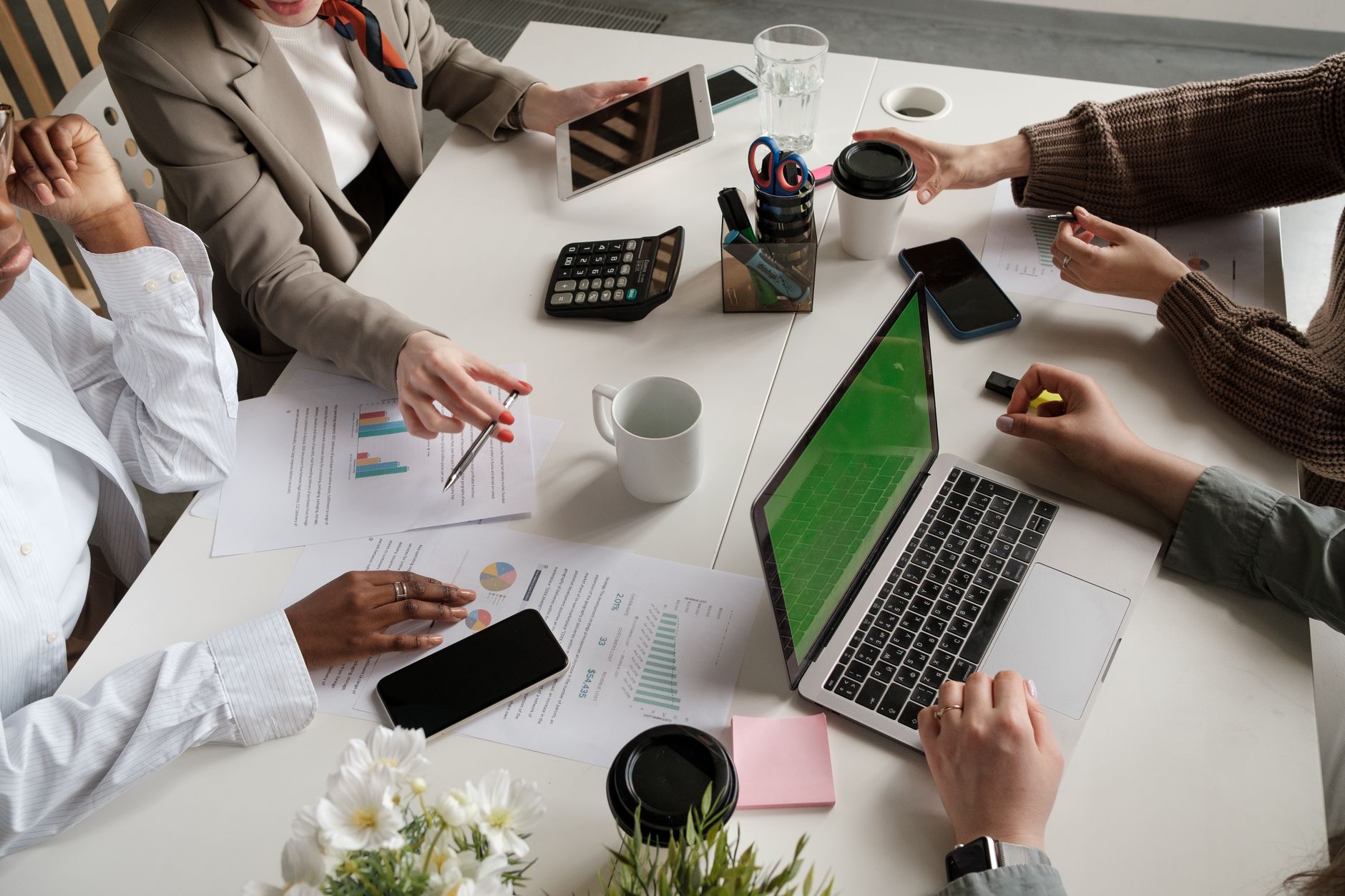 Marketing team collaborating around a monitor reviewing design files