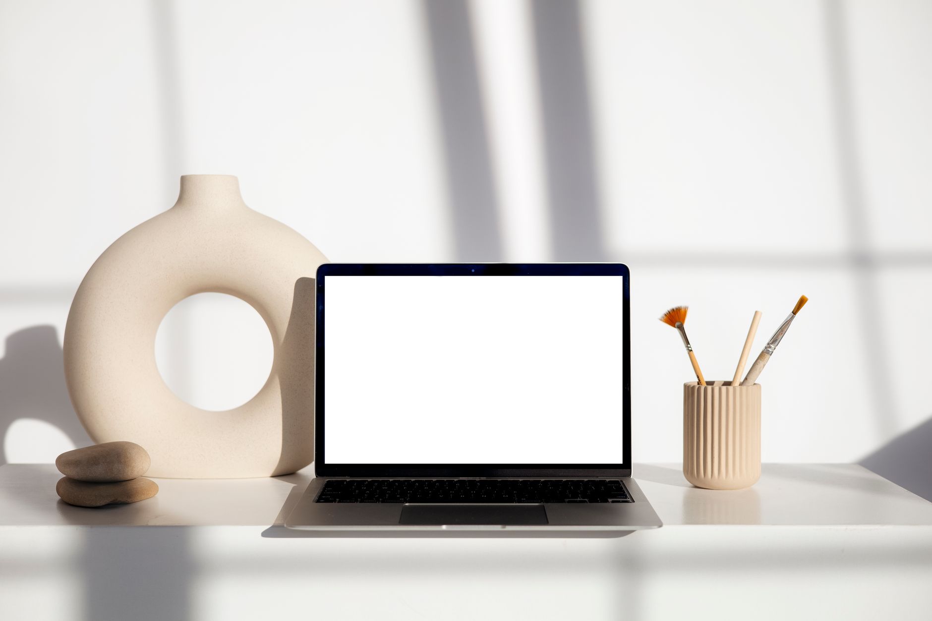 A designer working on a laptop in a collaborative workspace