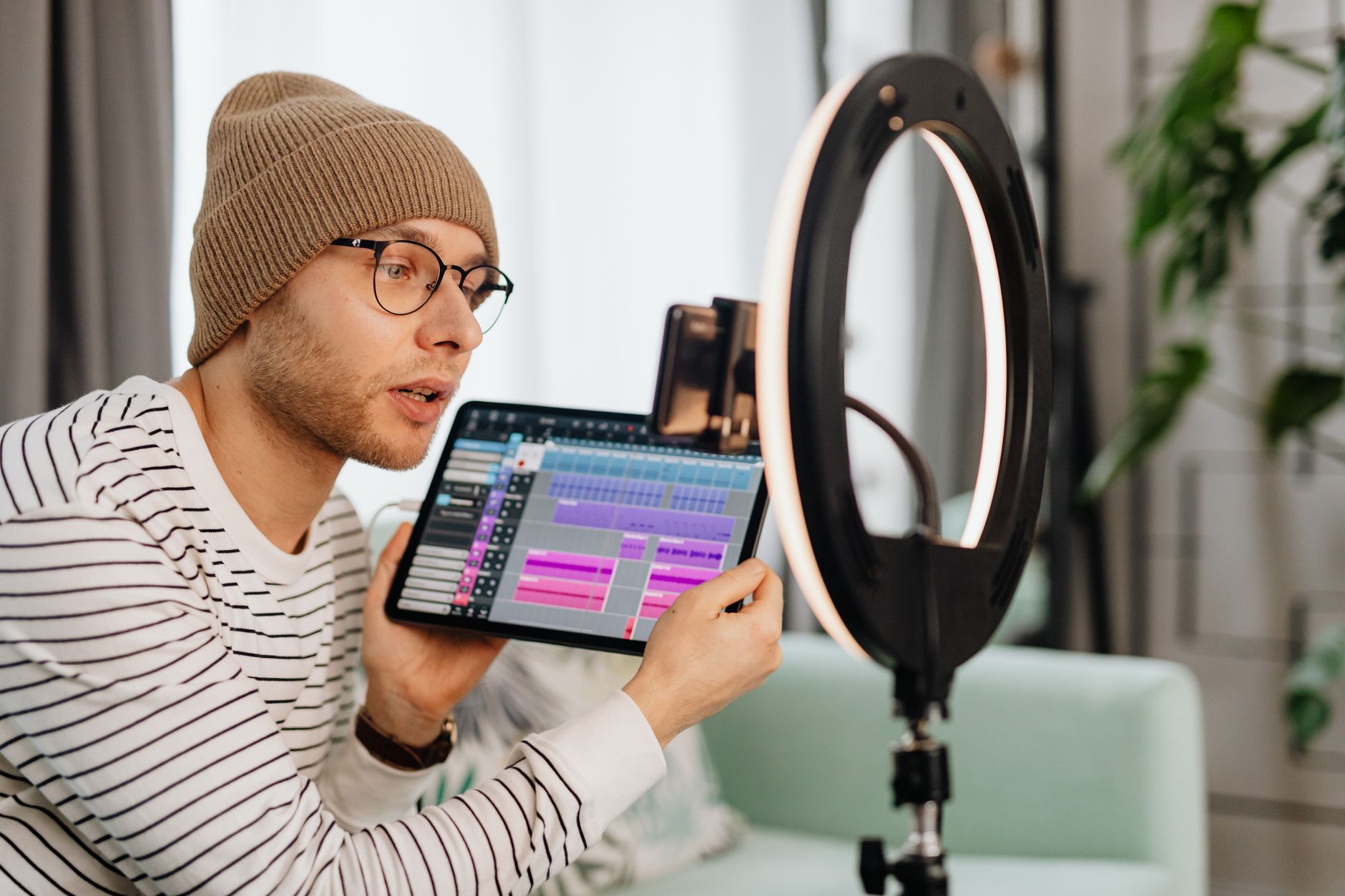 Solo video creator recording content in a home studio setup with monitor and microphone