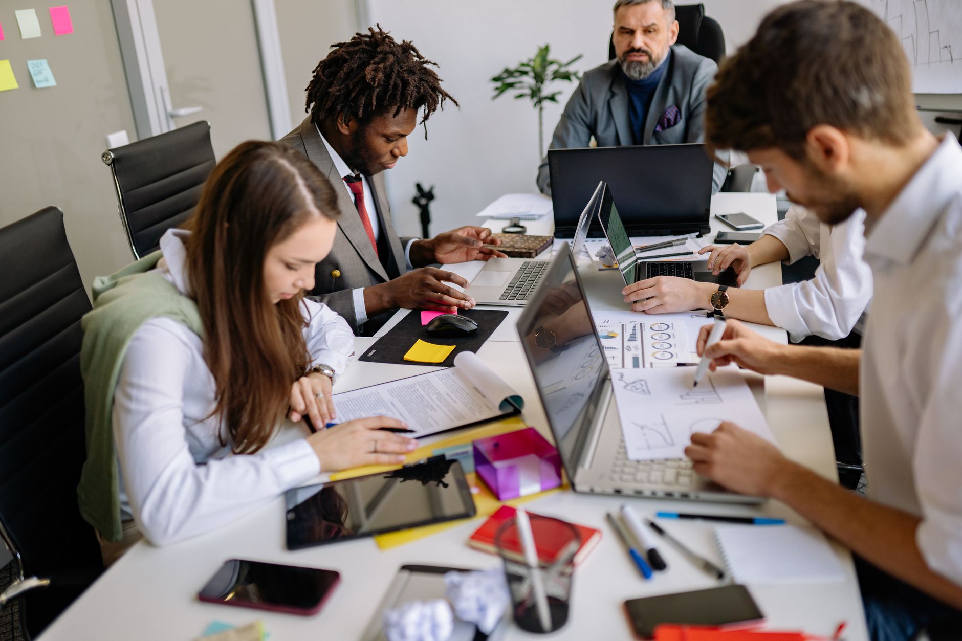 A small marketing team gathered around a monitor discussing digital advertising strategy