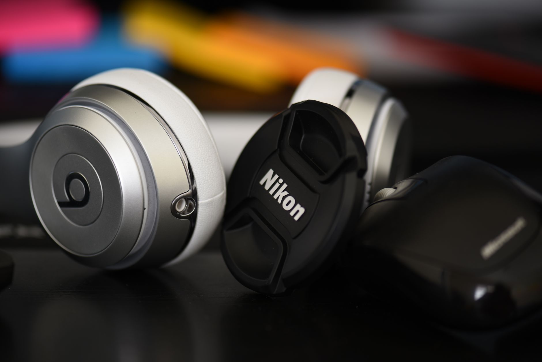 Headphones resting on a desk next to a laptop in a home recording environment