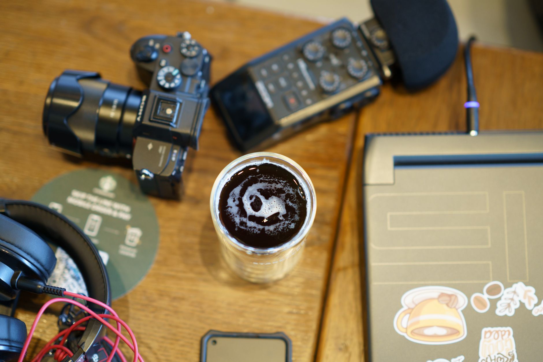 Content creator working at a desk with a laptop and phone, managing digital products