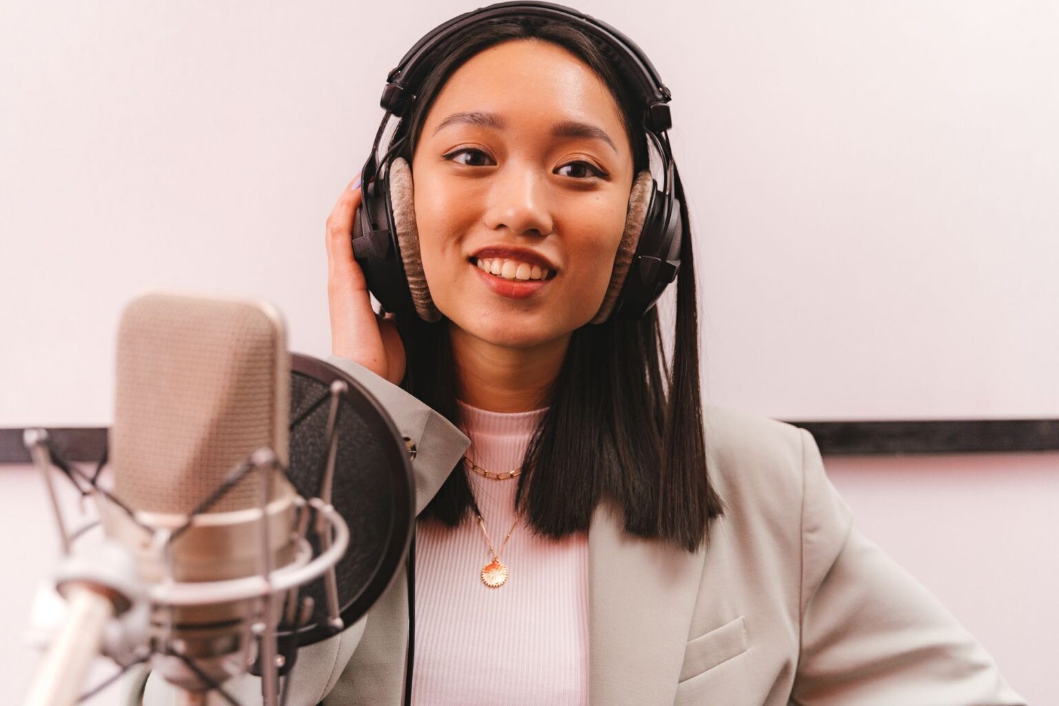 Castmagic’s AI Show Notes Are Edging Out Ausha for Podcasters Podcaster recording in a professional studio setup with microphone and headphones