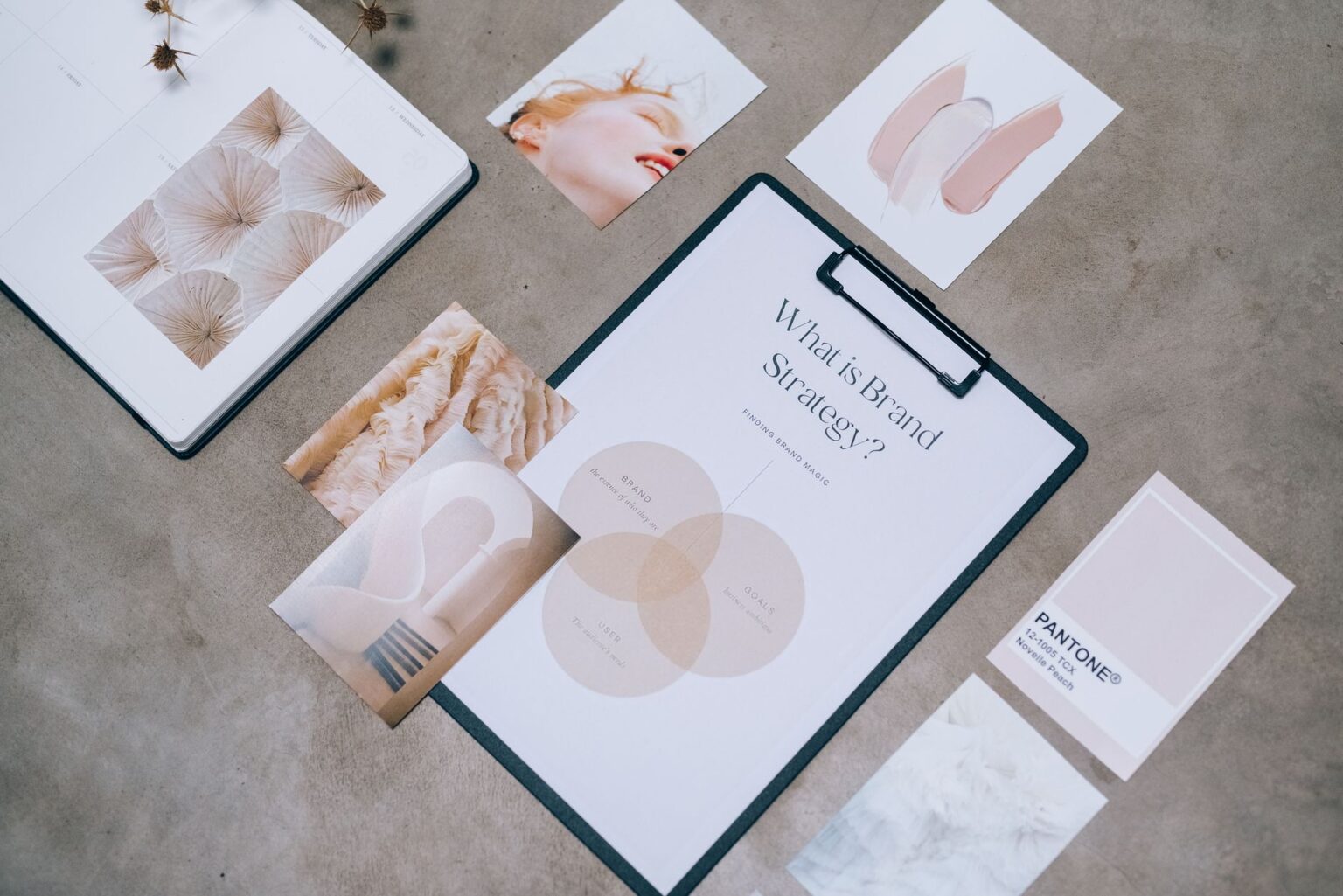 Cohesive AI’s Brand Kit Is Quietly Replacing Looka for Social Teams Designer working on brand identity materials at a desk with color swatches and a laptop
