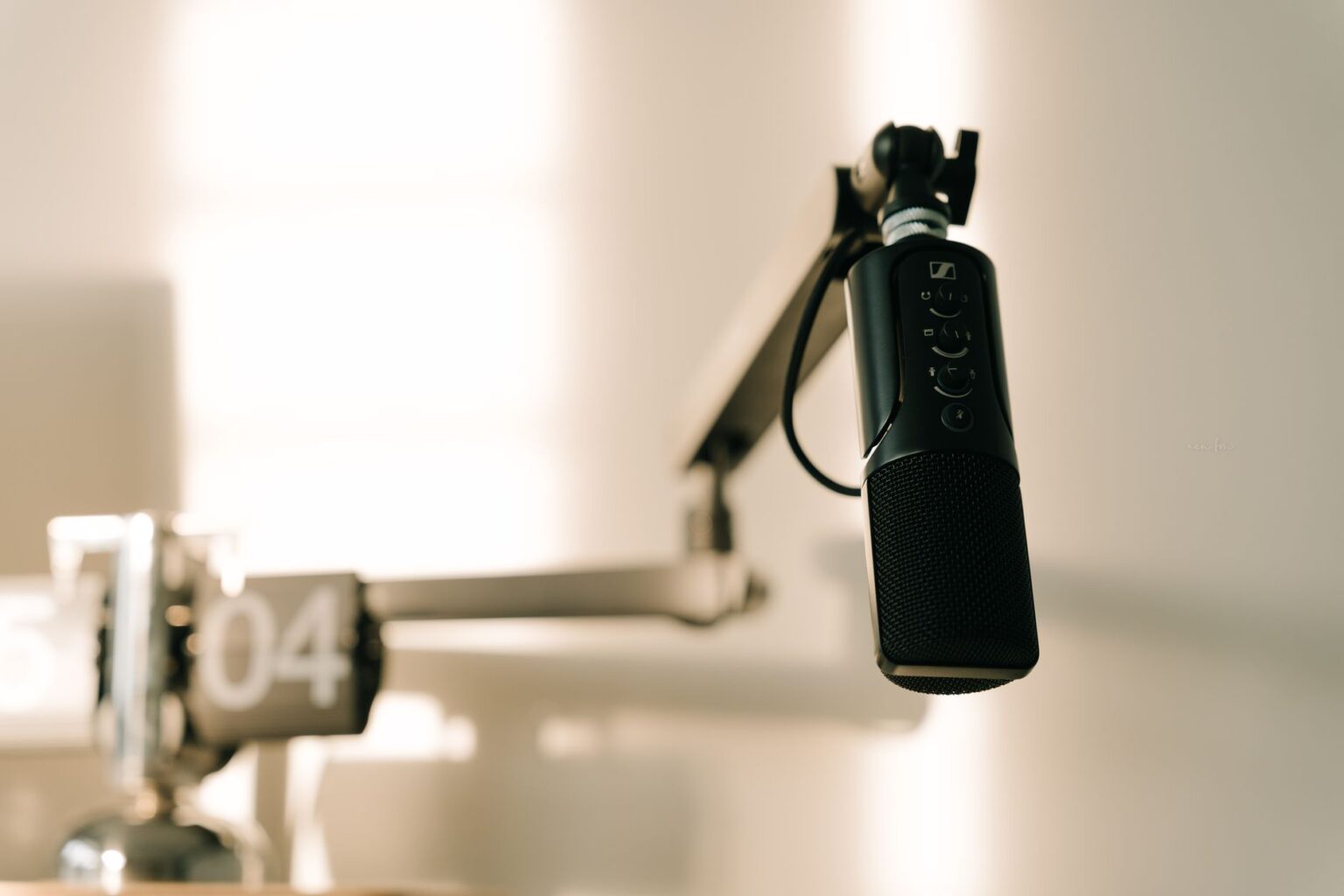 A clean podcast recording setup with microphone and headphones on a desk